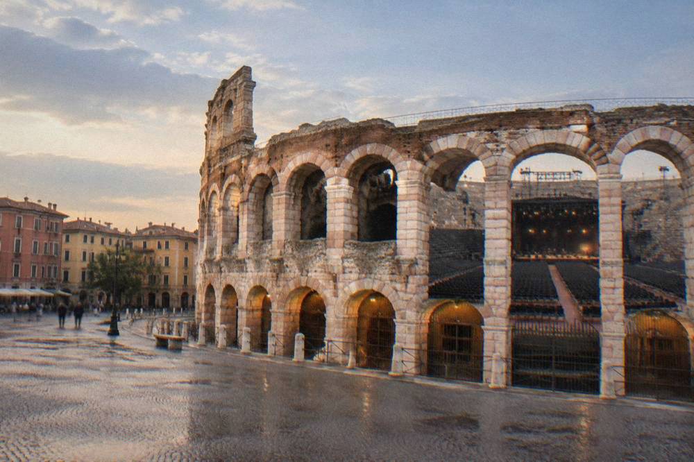 Rows of chairs arranged on the sand floor of the Verona Arena for an opera performance