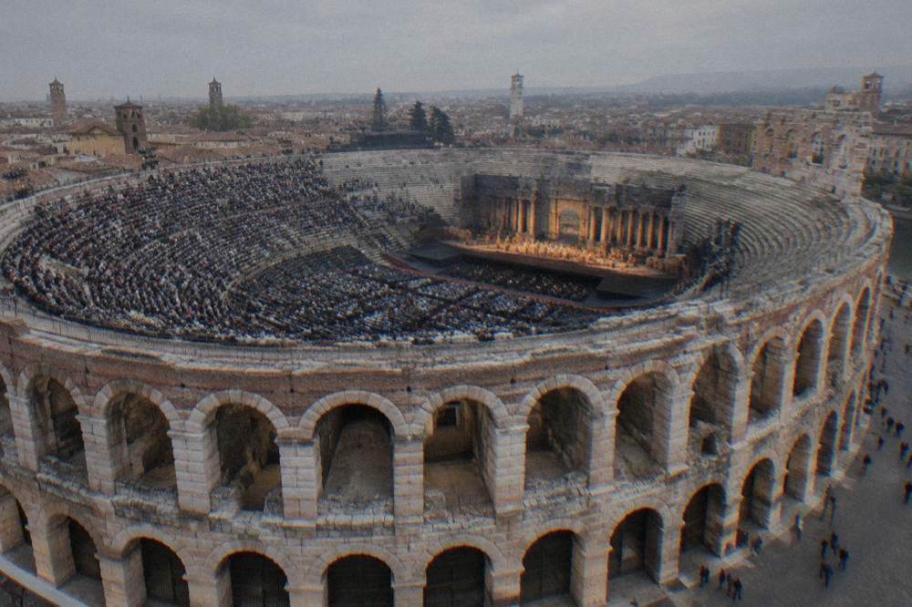 Audience members seated on stone tiers watching a stage lit for opera in the Verona Arena