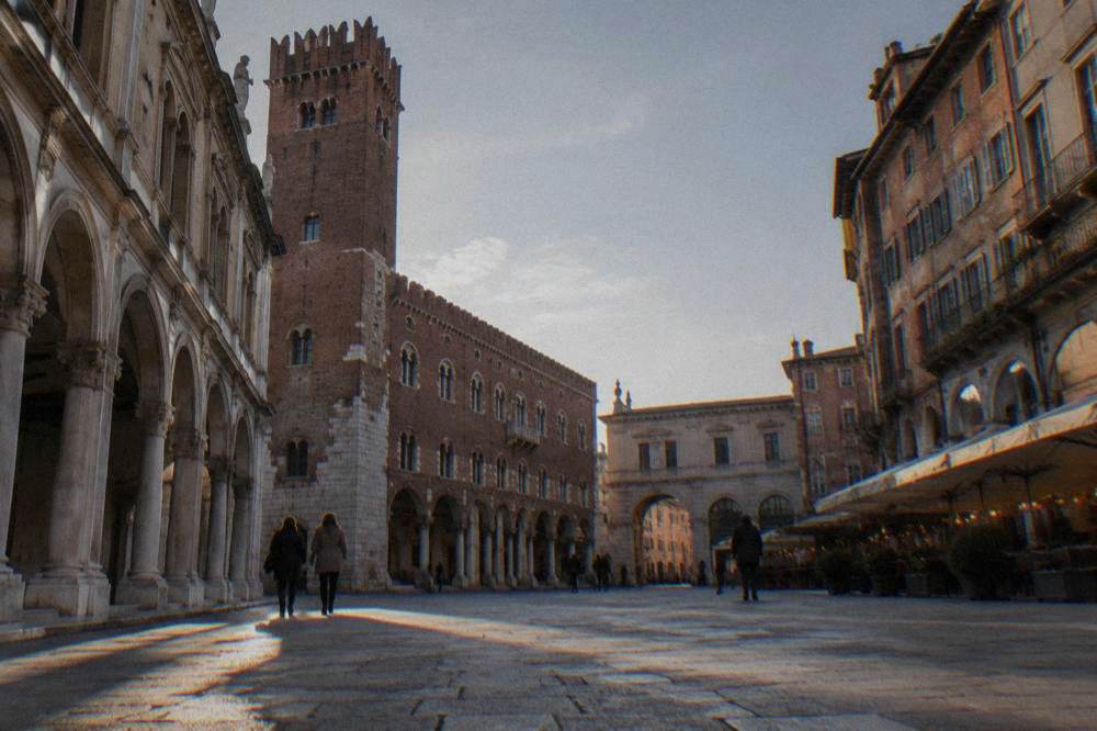 An evening street in an old Italian quarter with small restaurants lit along it