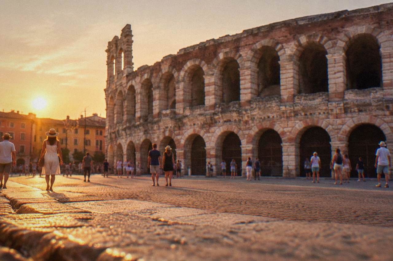 The Verona Arena amphitheatre seen from Piazza Bra under a warm evening sky