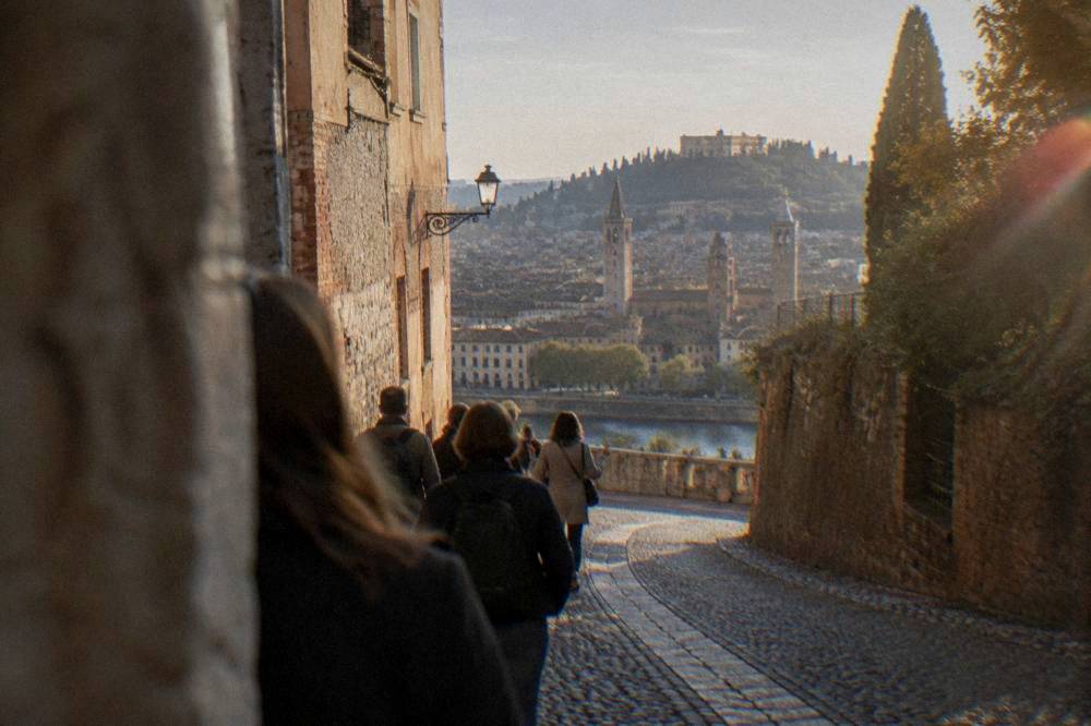 A small group of people following a guide down a narrow cobbled medieval street