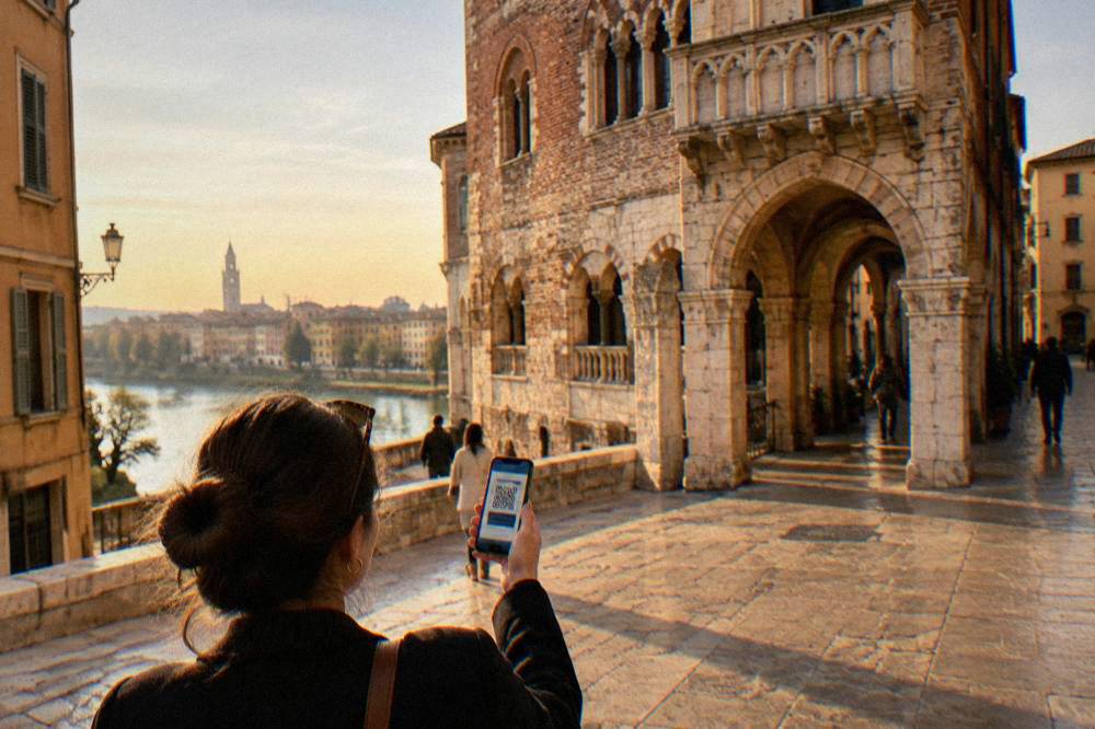 A visitor using a smartphone to show a digital ticket beside a historic Verona building