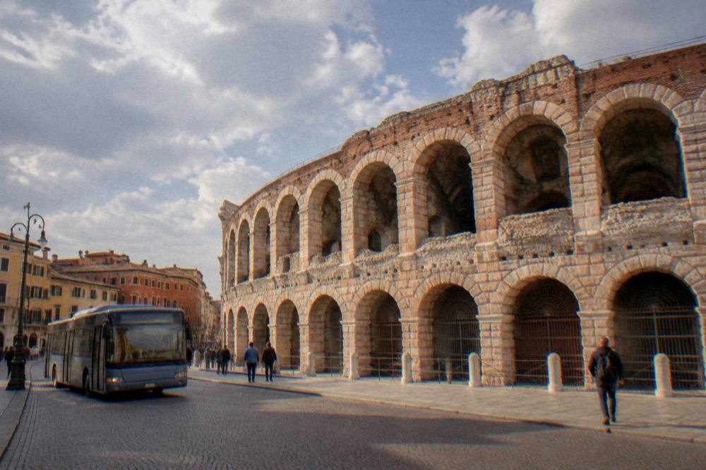 A city bus stopping on a street in central Verona near the Arena