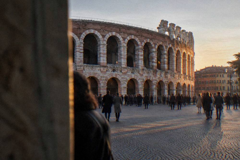Evening light on the Verona Arena and crowds on Piazza Bra before an opera night