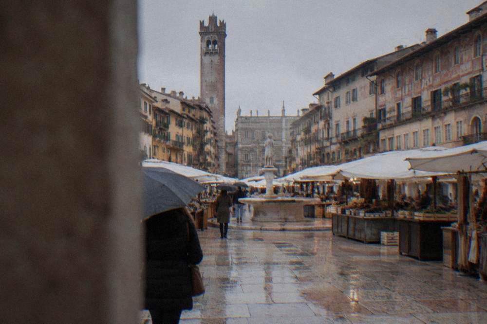 Market stalls and painted buildings around Piazza delle Erbe in Verona