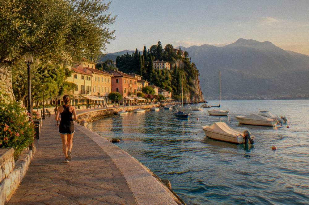 Boats moored on Lake Garda with a lakeside town and hills behind
