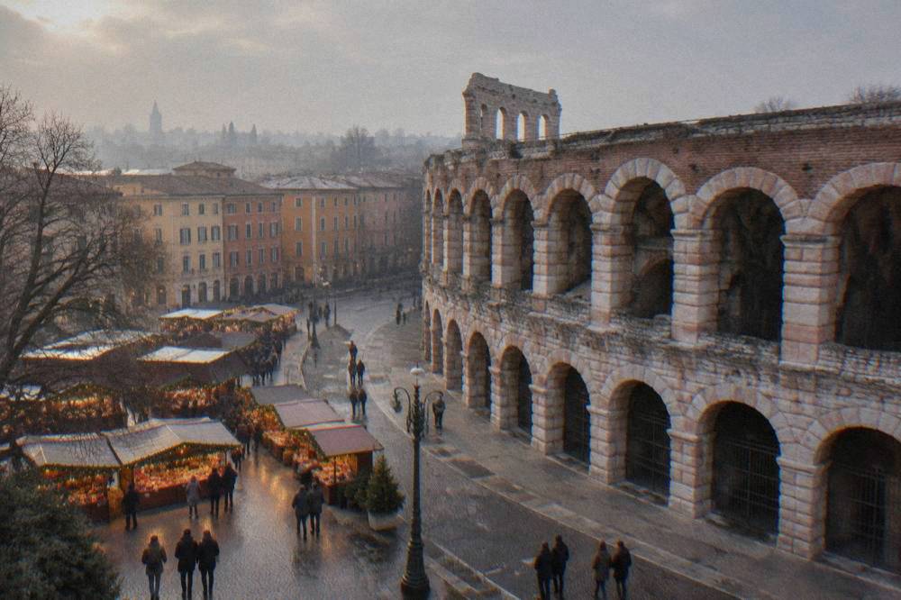 Christmas market stalls with warm lights in Piazza Bra beside the Arena in Verona