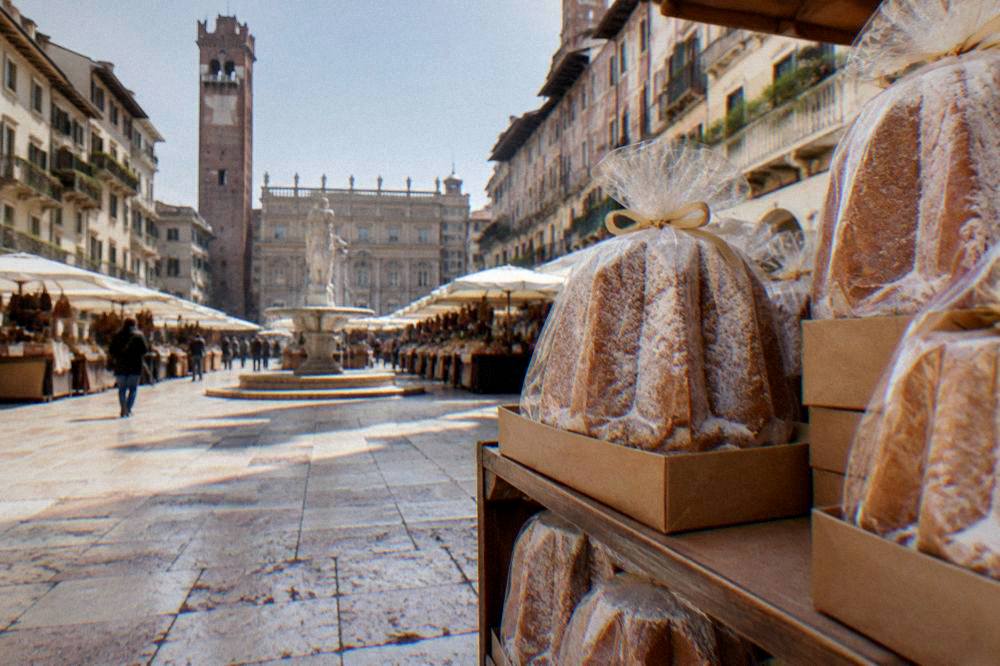 Wrapped and boxed pandoro cakes stacked on a shelf ready to carry home