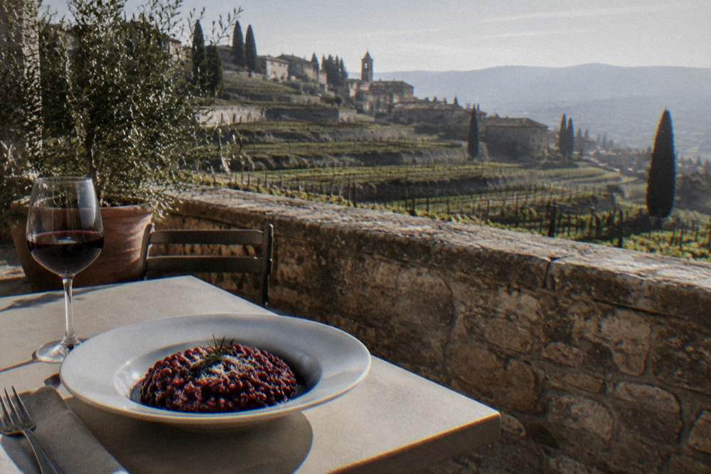 Plate of dark red wine risotto on a plain table, no labels