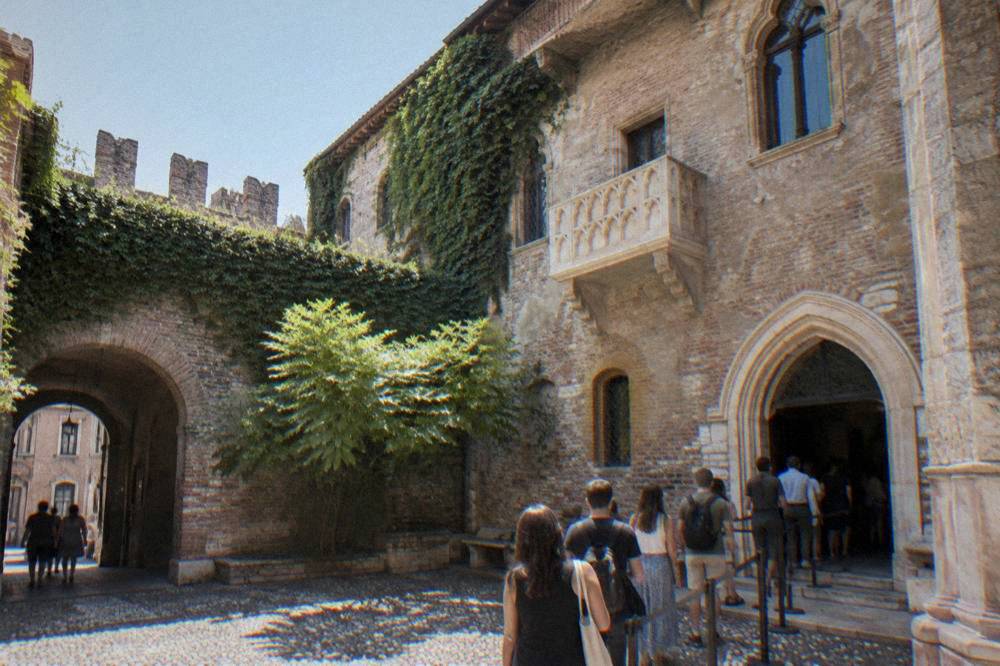 A ticket entrance to a museum in an old Italian palace with a small queue of people