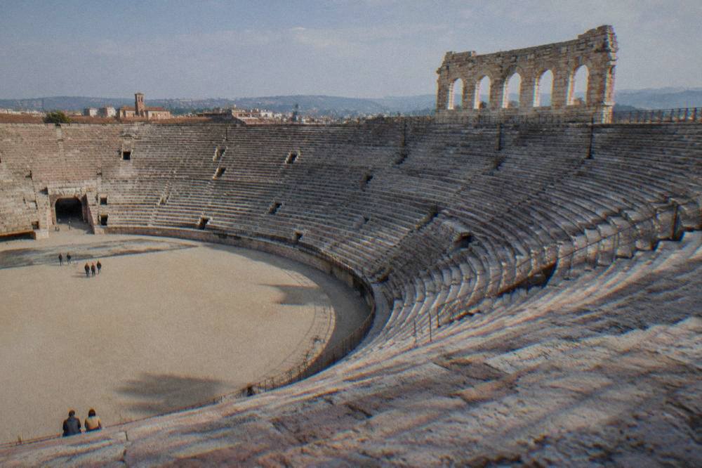 Interior of the Verona Arena showing stone tiered seating under daylight