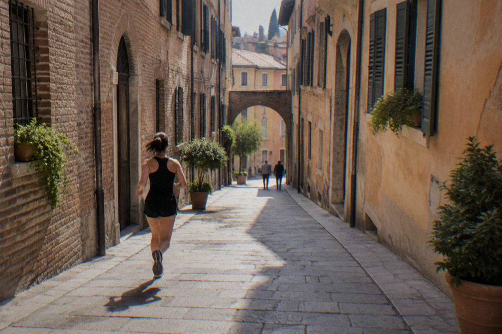 Narrow medieval street in central Verona with brick facades and shuttered windows