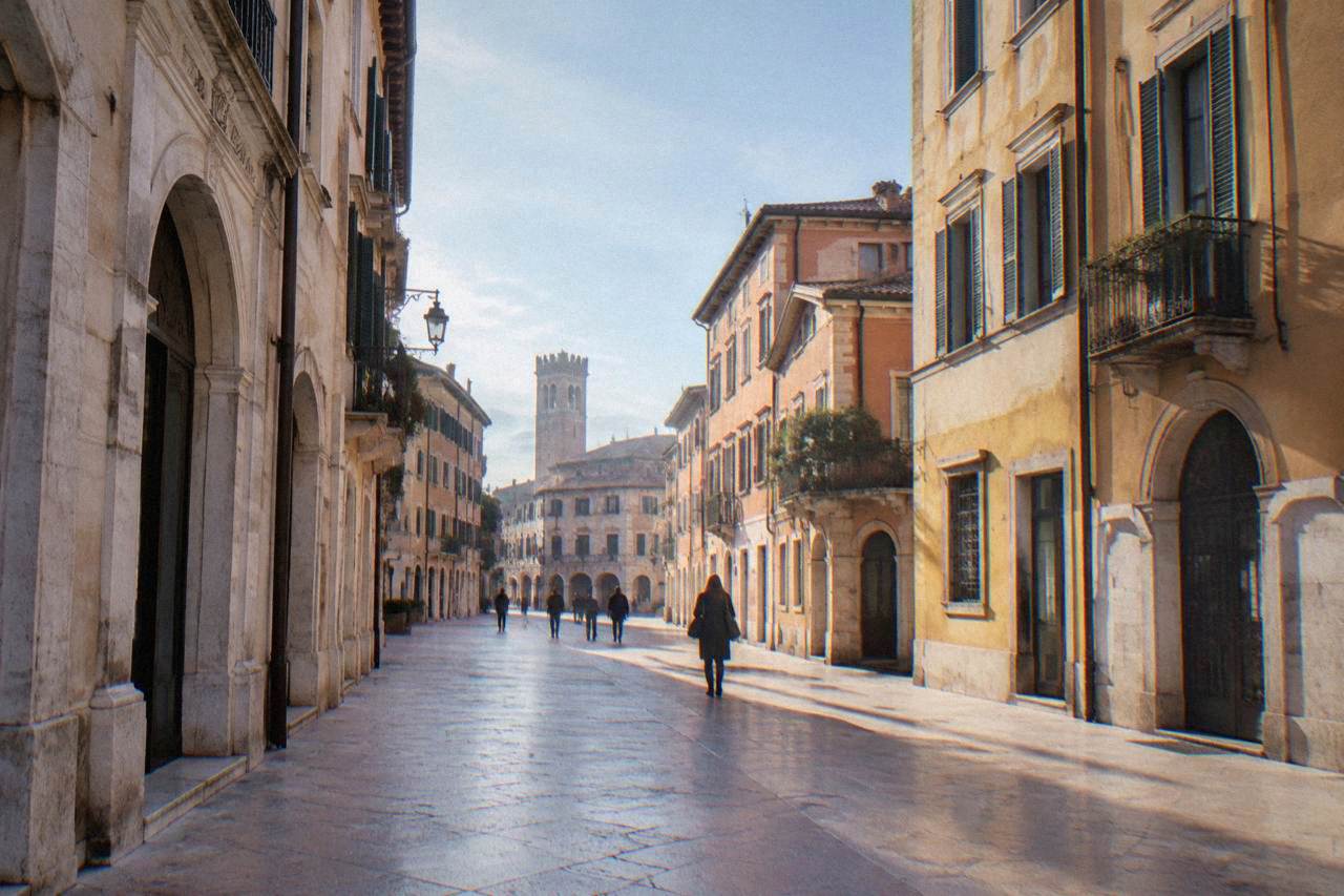 A smooth marble-paved street in central Verona with old buildings on both sides