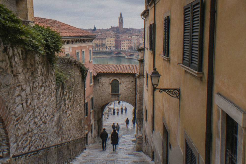 A narrow medieval lane in Verona with stone walls and a small archway