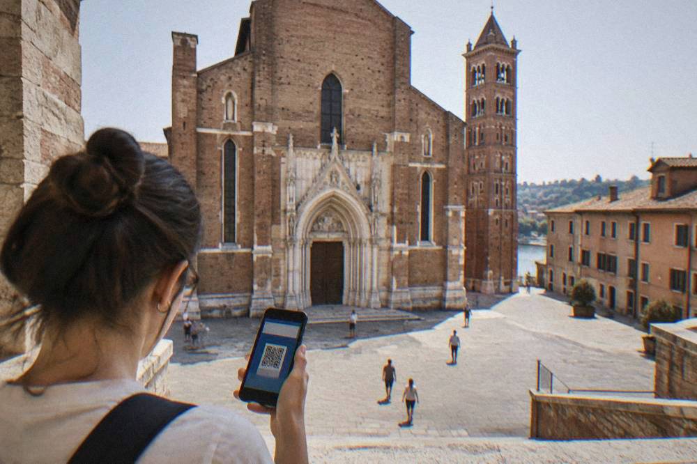 A visitor holding a smartphone showing a digital city pass at a church entrance