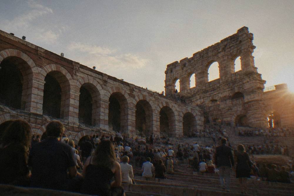 Crowds gathering at dusk on the stone steps inside the Arena di Verona before a performance
