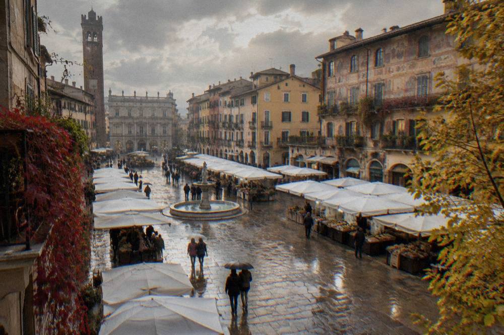 Rainy autumn afternoon on Piazza delle Erbe with market umbrellas and wet cobblestones