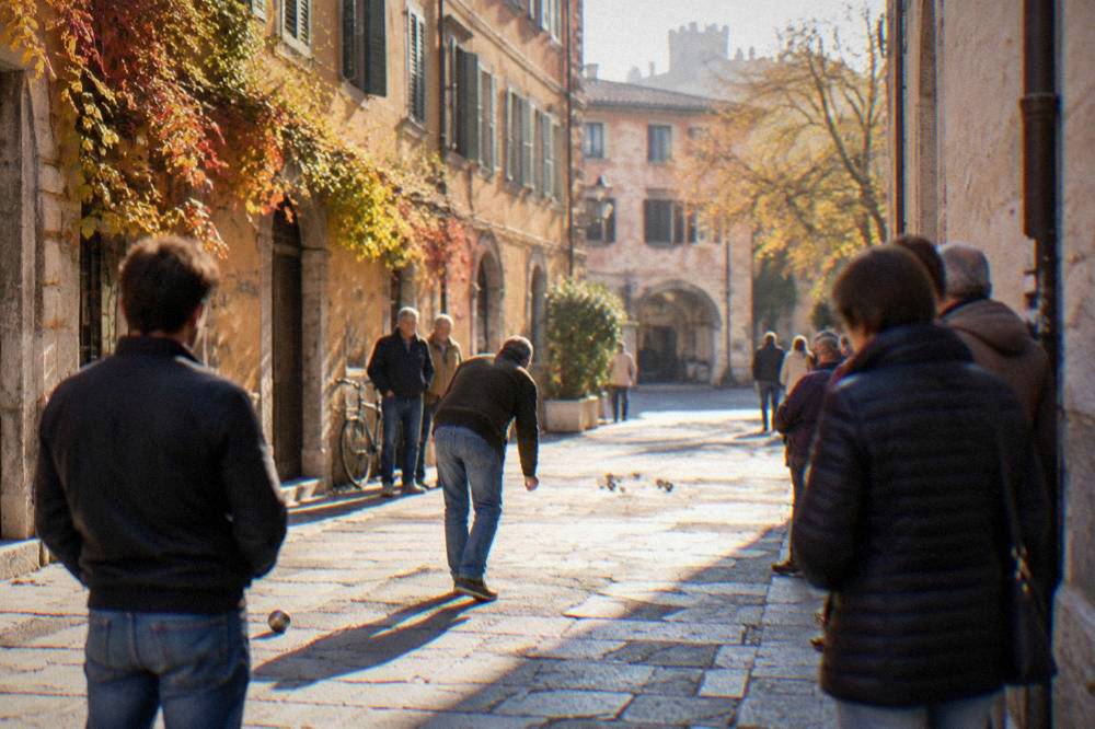 Street game players and spectators in a narrow Verona lane during a festival