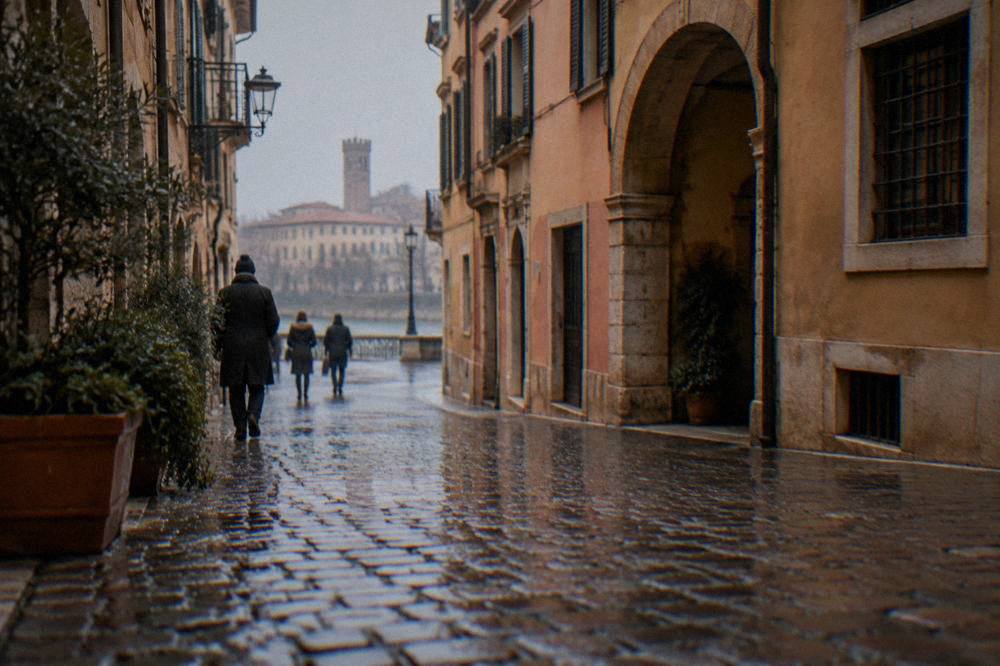A rain-wet cobbled lane in central Verona on a grey December morning