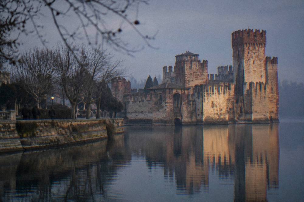 Scaliger castle walls at Sirmione reflected in still winter water