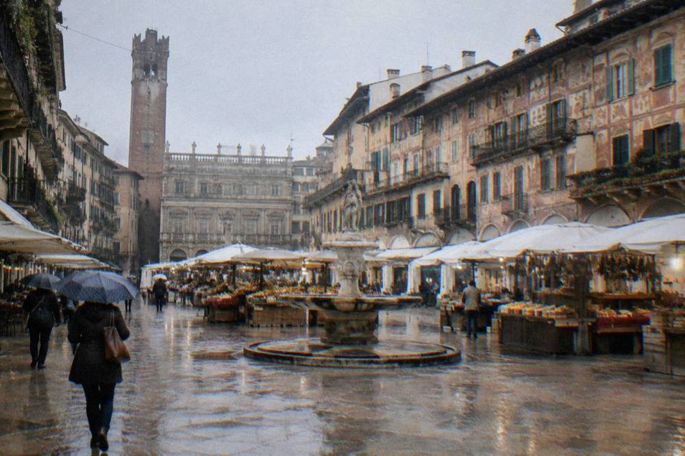 Piazza delle Erbe in Verona with market stalls and historic buildings under morning light
