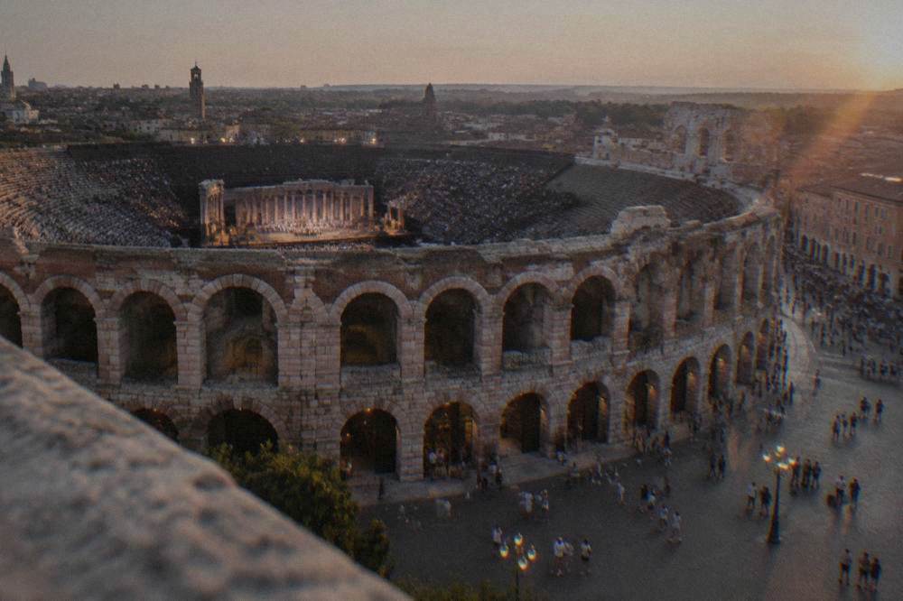 The Arena di Verona lit at night with stage lighting inside the open amphitheatre