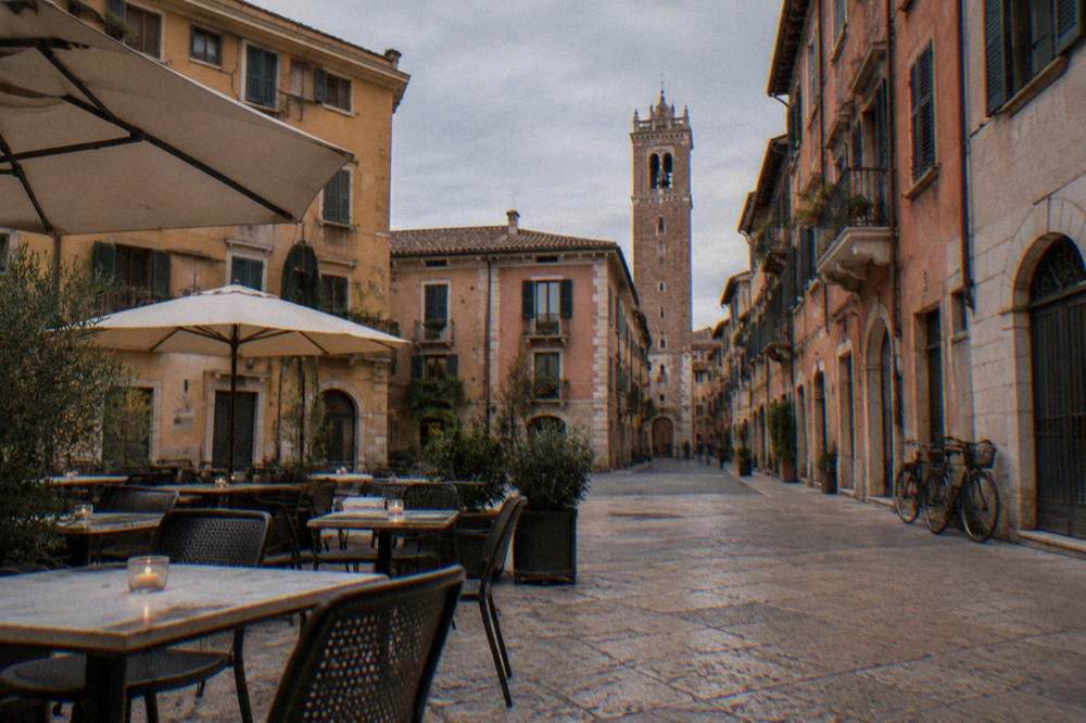 Outdoor cafe tables on an old square in the evening, no people in focus
