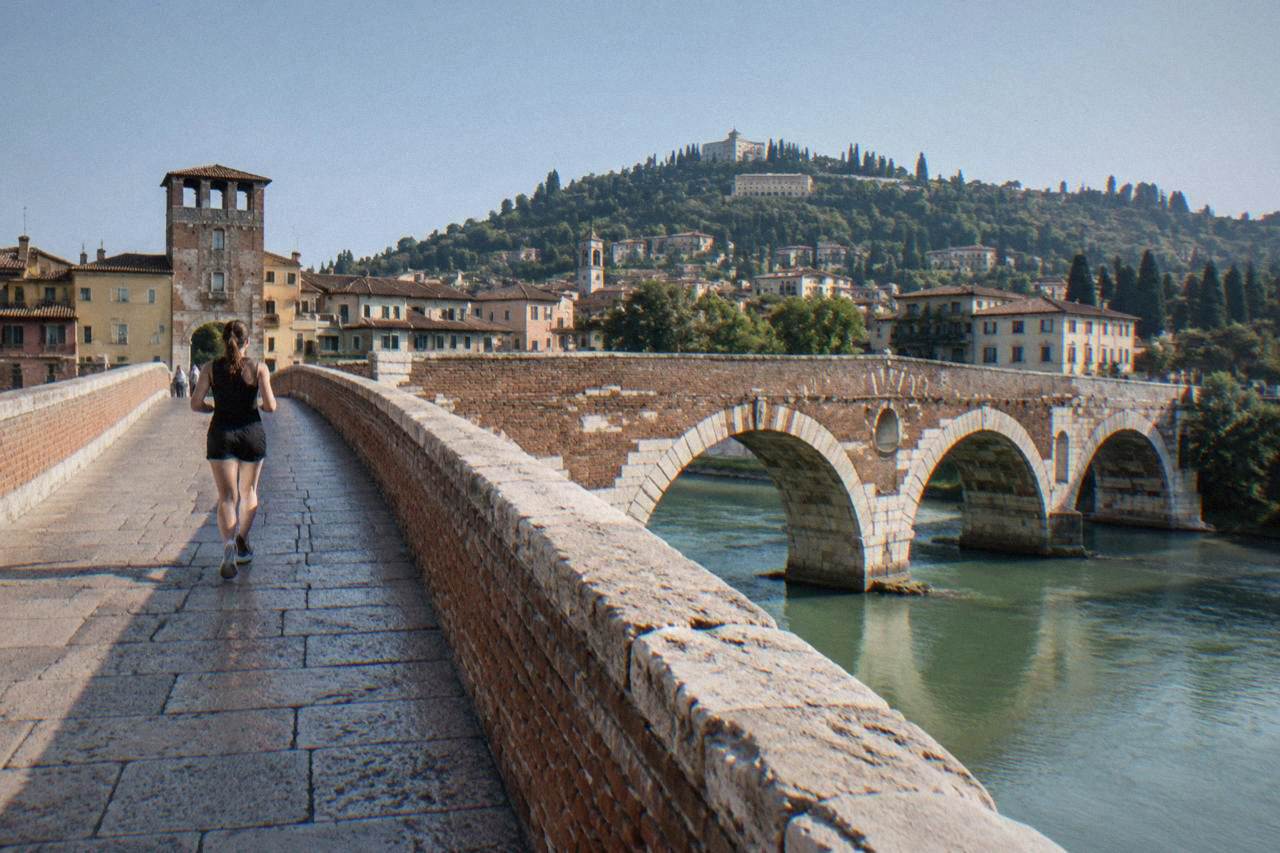 The Roman arches of Ponte Pietra crossing the Adige river with Verona's hillside behind