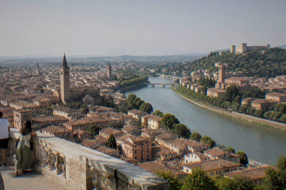 Verona's terracotta rooftops seen from a high terrace with the Adige river curving past