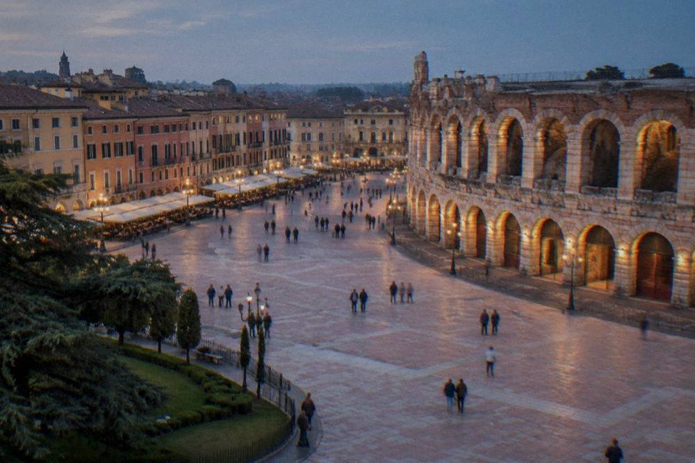 Evening light on the Arena's arched facade from the open edge of Piazza Bra