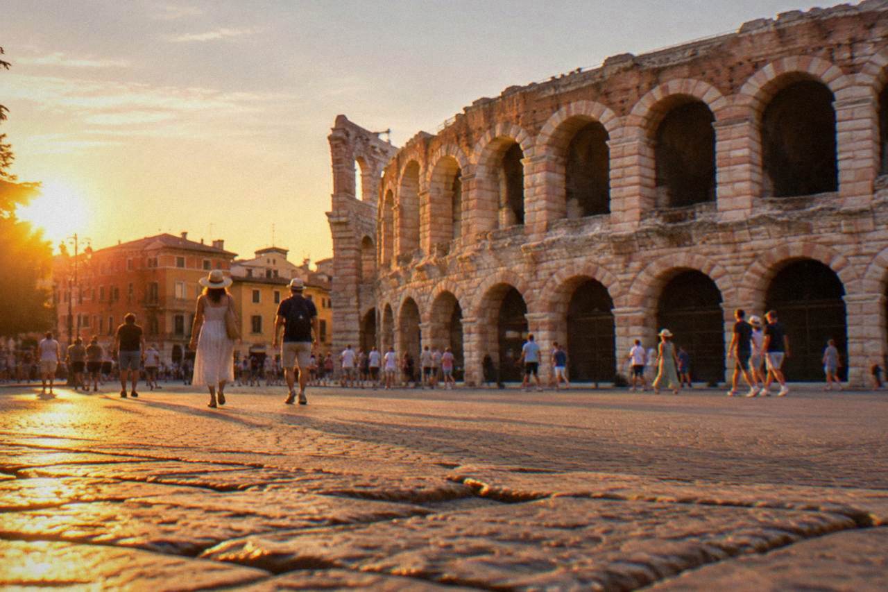 Evening light over Piazza Bra in Verona with the Arena amphitheatre on the right and people crossing the square