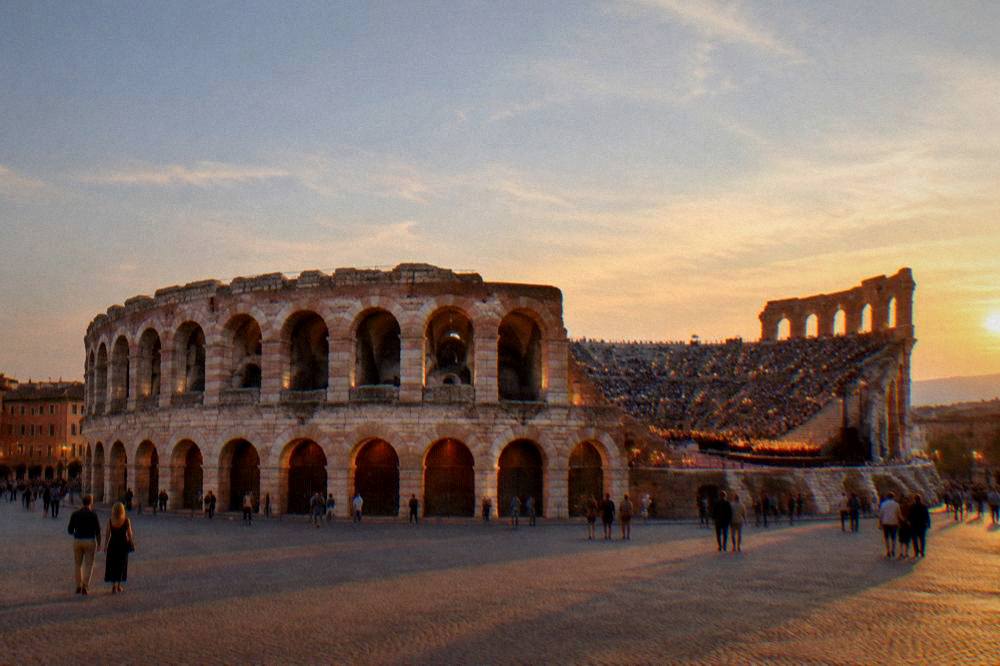 Candle-lit steps inside the Verona Arena on an opera night with the audience seated on the stone tiers under the open sky