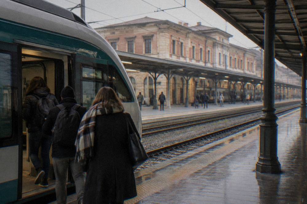 A regional train at a platform inside Verona Porta Nuova station with passengers boarding