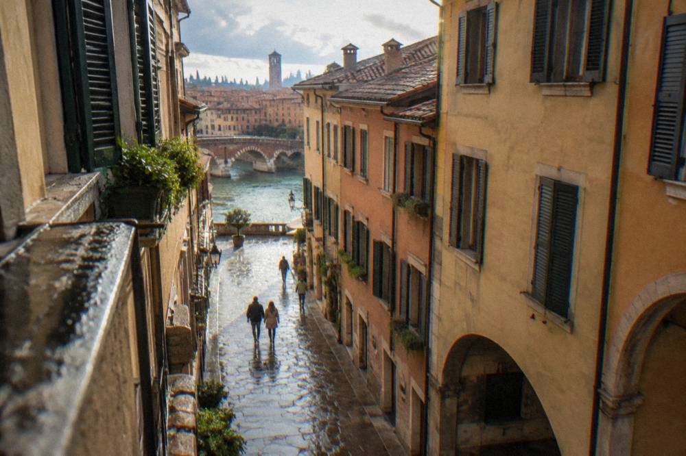 Rain-washed cobblestones in a narrow Verona street with wet stone walls