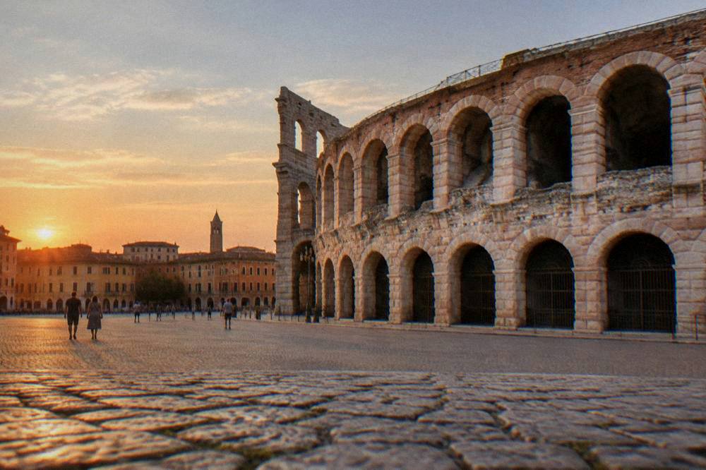 The Verona skyline at dusk with the Arena and rooftops under a soft evening sky