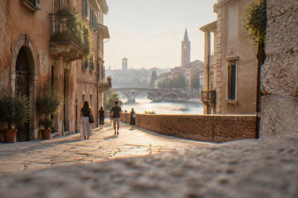 Pedestrians walking a cobbled lane in central Verona at golden hour with no cars present