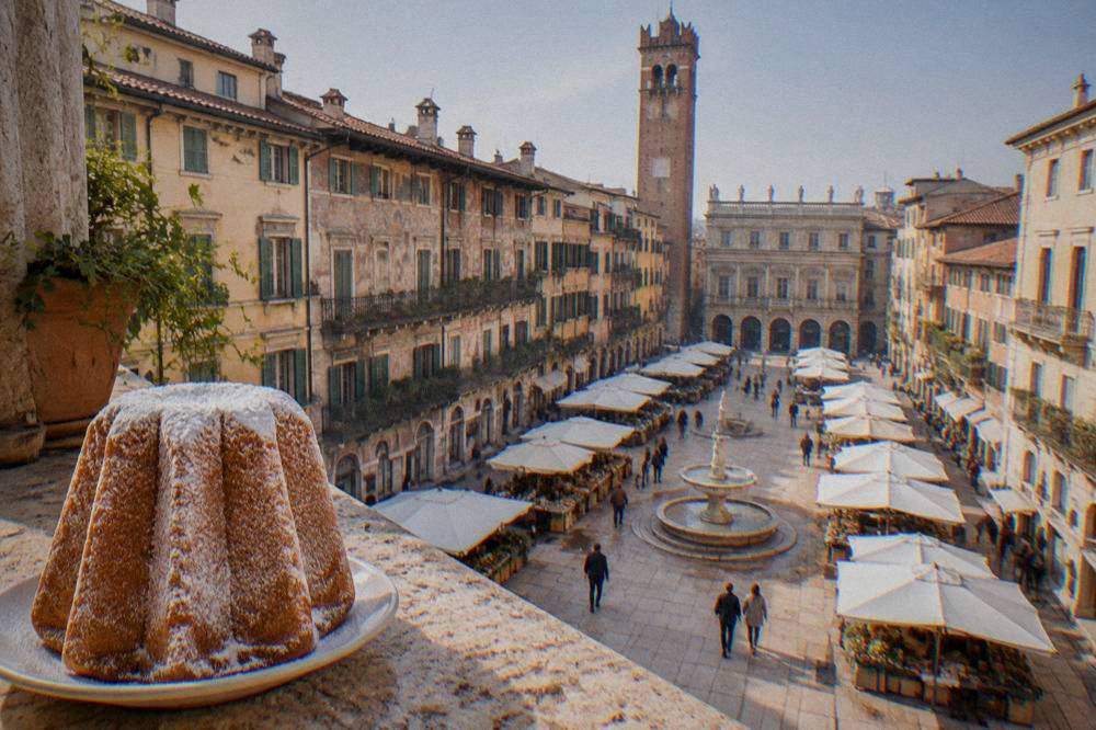 A tall star-shaped pandoro cake dusted with icing sugar on a plate