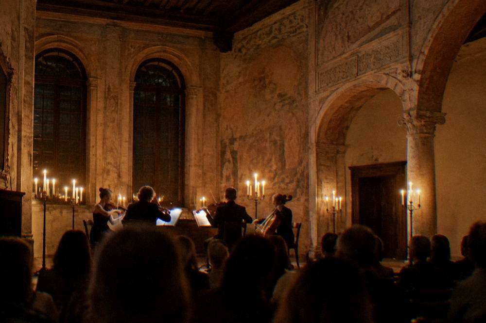 A candlelit concert hall inside a historic Verona palace