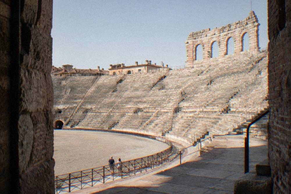 The stone steps and arches of Verona's Arena interior in daylight