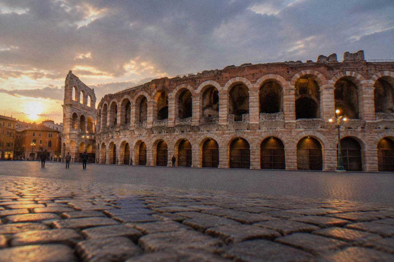 The illuminated Roman Arena of Verona seen from Piazza Bra at dusk