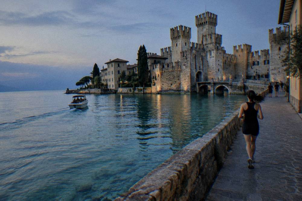 A small boat crossing clear water toward Sirmione's peninsula