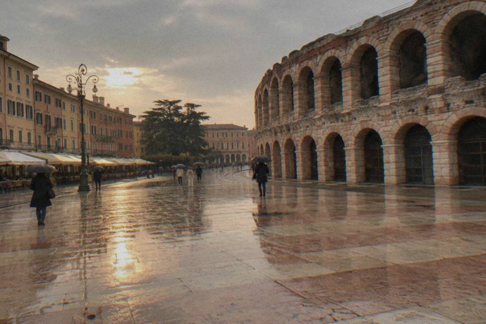 Rainy view of Piazza Bra in Verona with the Arena's facade behind wet pavement