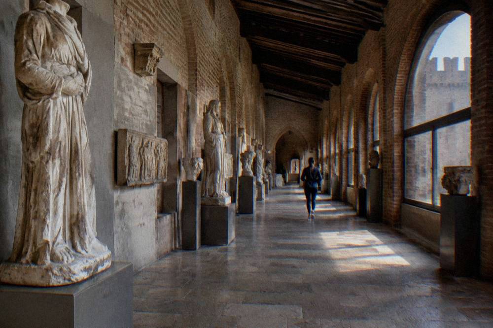 Interior gallery of Castelvecchio museum in Verona with medieval sculpture along the walls