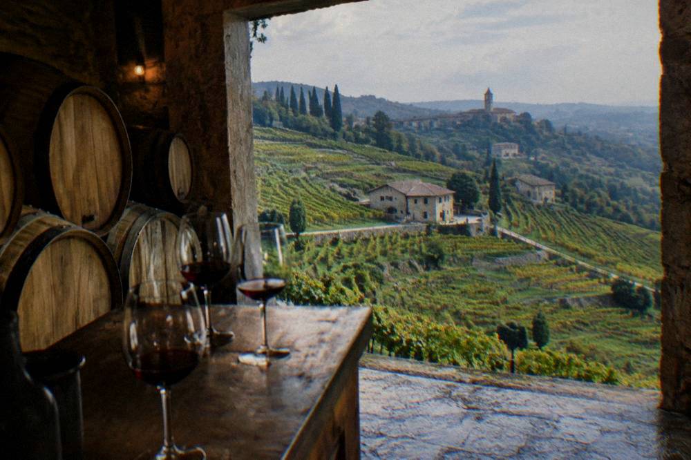 Wine barrels in a dim Valpolicella cellar with glasses of red wine on a tasting counter