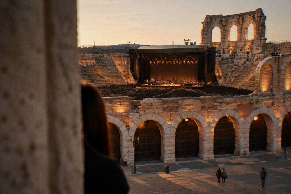 An opera stage lit inside the Arena of Verona at night