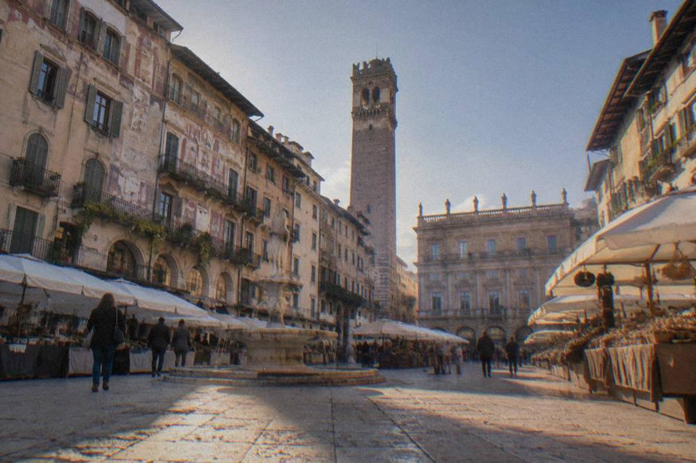 Piazza delle Erbe market stalls with frescoed buildings in Verona