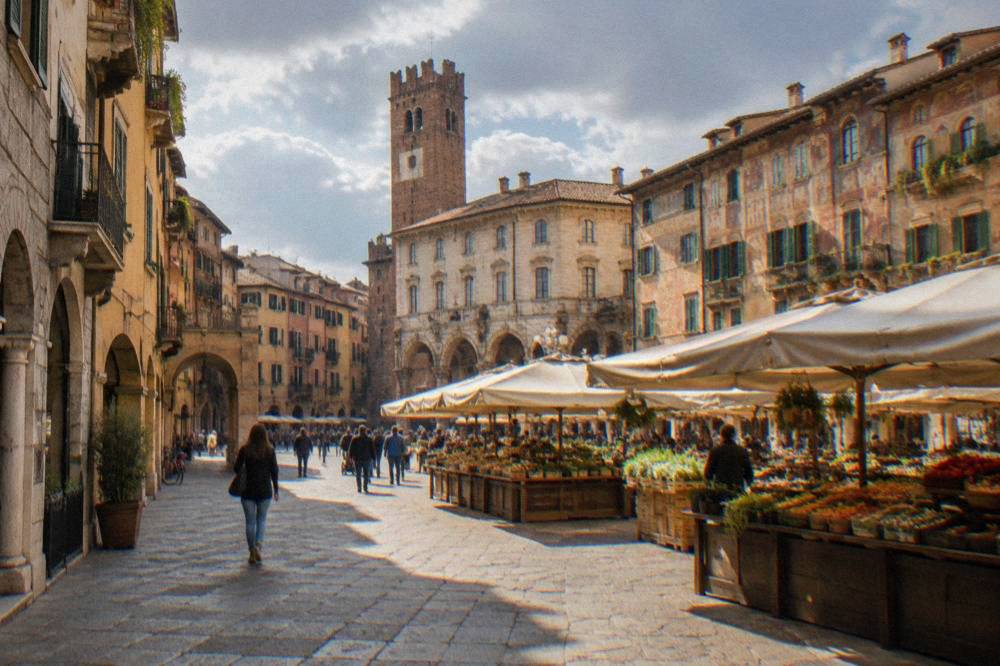 A medieval square lined with frescoed buildings and market stalls in Verona