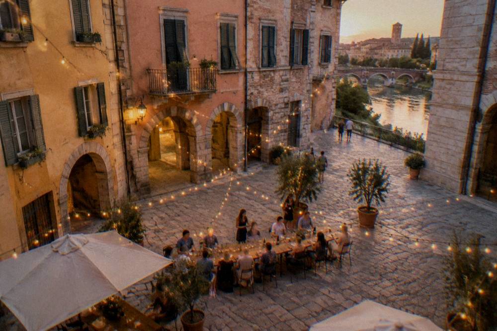 An evening tasting table set outdoors on a Verona piazza under string lights