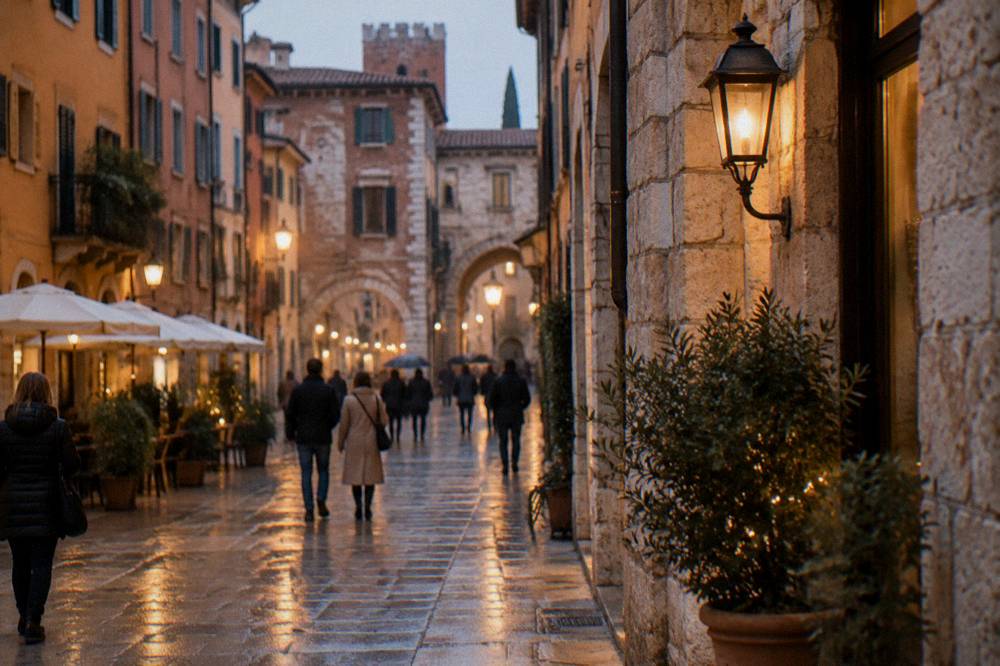 An evening street in Verona lit by warm lamps with people strolling